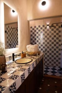 Un baño con lavabo y azulejos azules y blancos. en Casa Maka, en San Luis Potosí