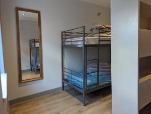 a room with bunk beds and a mirror at Hostel Rooms In Camden in London