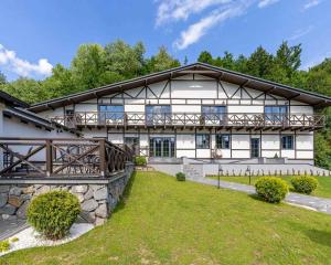 Elle offre une vue sur l'extérieur d'un grand bâtiment blanc doté d'un balcon. dans l'établissement Private House Scherbovets, à Zhdenievo