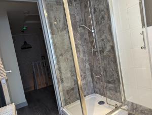 a bathroom with a shower with a glass door at Hostel Rooms In Camden in London