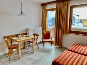 una camera con tavolo, sedie e letto di Appartementhaus Grocke a Wagrain