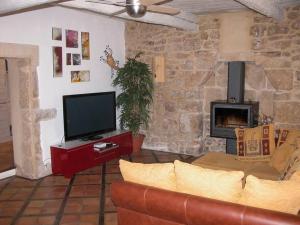 sala de estar con sofá, TV y chimenea en studio au pied des troglodytes, près de la plage, en Saint-Chamas