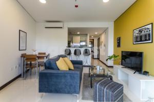 ein Wohnzimmer mit einem blauen Sofa und einem TV in der Unterkunft Comfy Villa Morra Apt in Asunción