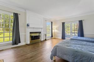 a white bedroom with a bed and a fireplace at The Swan in Petersburg