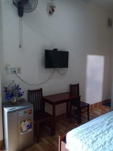 een kamer met een tafel en een tv aan de muur bij Manh Phat Guesthouse - Nhà Nghỉ Mạnh Phát in Can Tho