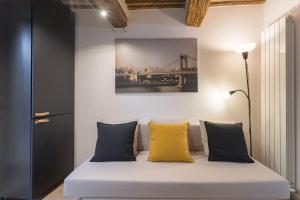 Cette chambre comprend un lit avec deux oreillers jaunes. dans l'établissement MaRì Modern Flat - Nel cuore verde di Perugia - Posto Auto, à Pérouse