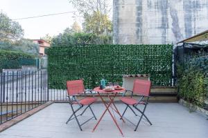 a table with two chairs and a table with food on it at MaRì Modern Flat - con Posto Auto e vicino alla Metro - ItalyWeGo in Perugia