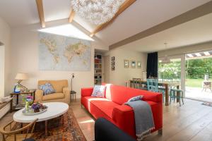 ein Wohnzimmer mit einem roten Sofa und einem Tisch in der Unterkunft Zoomgronden Renesse in Renesse