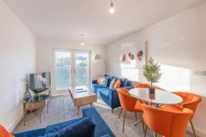 a living room with a blue couch and a table at Gospel Heights Luxury Apartments With Parking in Heswall