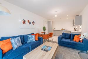 a living room with a blue couch and a table at Gospel Heights Luxury Apartments With Parking in Heswall