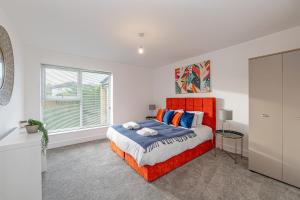 a bedroom with an orange bed and a window at Gospel Heights Luxury Apartments With Parking in Heswall