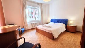 a bedroom with a bed with a blue head board at Flat Barbariga 12 in Trieste