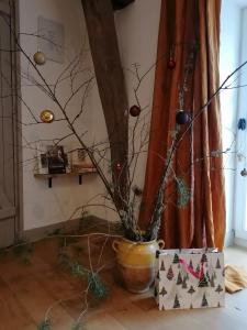 Un jarrón con adornos de Navidad en una habitación en La Robinière Maison d'Hôtes en Mont-près-Chambord