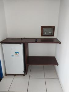 a desk with a microwave on top of a refrigerator at Pousada Flores da Terra in Paraty