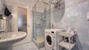 a bathroom with a washing machine and a sink at Flat Barbariga 12 in Trieste