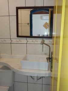 a bathroom with a sink and a mirror at Pousada Flores da Terra in Paraty