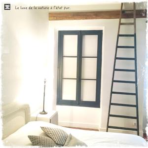 a bedroom with a ladder next to a bed and a window at L'académie de Clémence, Guest House Paris-Roland-Garros in Boulogne-Billancourt