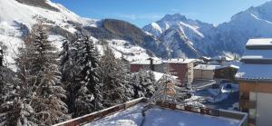 a resort with snow covered mountains in the background at Charmant Studio 4 pers plein centre Parking privé in Les Deux Alpes