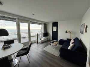 ein Wohnzimmer mit einem Sofa und einem Tisch mit Stühlen in der Unterkunft Ferienwohnung Fördedeck in Kiel