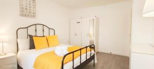 ein Schlafzimmer mit einem großen Bett mit gelben Kissen in der Unterkunft Woodfield apartment in The Hyde