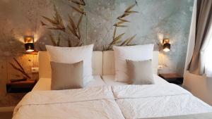 a bedroom with a bed with white sheets and pillows at Bergische Idylle in Overath