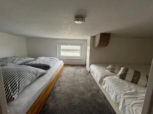 two beds in a small room with a window at Ferienwohnung Fördedeck in Kiel