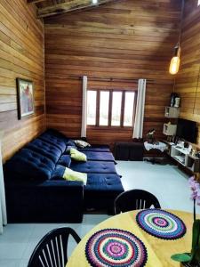 een woonkamer met een blauwe bank en een tafel bij Casa para Alugar para Show Rural Cascavel 2024 in Cascavel