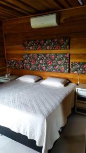 een slaapkamer met een bed met een houten hoofdeinde bij Casa para Alugar para Show Rural Cascavel 2024 in Cascavel