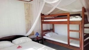 a bedroom with two bunk beds in a room at Residence Monique in Ile aux Nattes