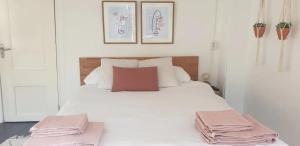 a bedroom with a white bed with pink towels on it at Studio's in the Center of Amsterdam with Canal View! in Amsterdam