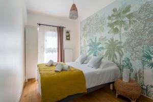 um quarto com uma cama grande e um cobertor amarelo em MAISON STELLA em Villeurbanne