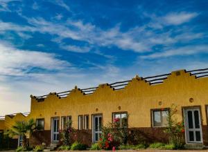 a yellow building with a blue sky in the background at Equinox in Tan-Tan Plage