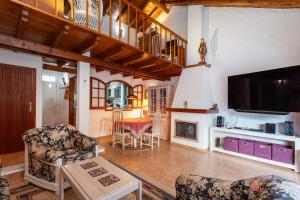 a living room with a fireplace and a tv at Le jardin de Teresa in Algoz