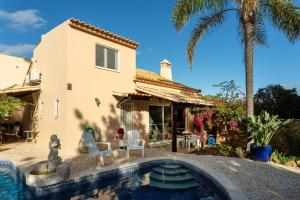 a house with a swimming pool in front of a house at Le jardin de Teresa in Algoz