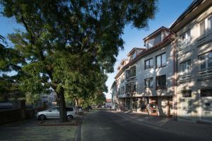 a street in a city with a tree and buildings at Castle Wall Apartment in Bratislava
