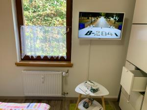 einen TV an einer Wand in einem Zimmer in der Unterkunft Apartment im Herrenwäldchen in Brombachtal