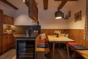 a kitchen with a wooden table and a dining room at Urhof Chalet in Liesing