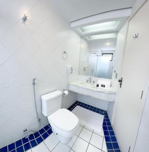 a white bathroom with a toilet and a sink at Momax Hotel in Marília