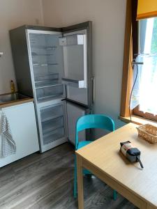 eine Küche mit einem Tisch und einem Kühlschrank in der Unterkunft Apartment im Herrenwäldchen in Brombachtal