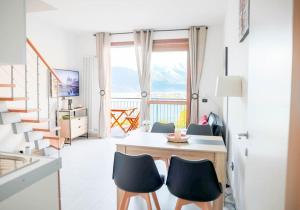 een woonkamer met een tafel en stoelen en een balkon bij BELLANOOTJE by Design Studio in Bellano