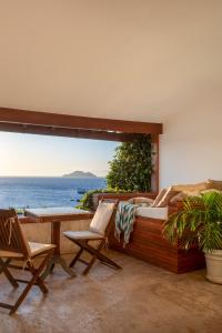 a balcony with chairs and a bed and a view of the ocean at Casas Brancas Boutique Hotel & Spa in Búzios