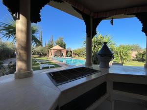 a porch with a swimming pool and a house at Authentic Villa Ideal for 16+ guests in Marrakesh