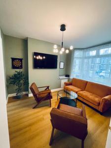 a living room with a couch and chairs and a tv at Stunning house in Anfield, whole house in Liverpool