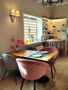 uma cozinha com uma mesa e algumas cadeiras cor-de-rosa em Őri Art Inn em Oriszentpéter