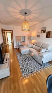 a living room with a couch and a television at Apartamentos San Martin Ourense Centro 2 in Ourense