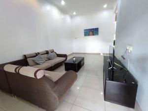 un soggiorno con divano e TV di Sayang-Sayang Homestay $CRAZY OFFER$ 4R2B a Batu Pahat