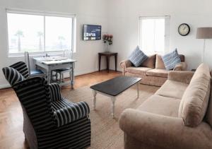 a living room with a couch and a table at Villa Capri in Cape Town