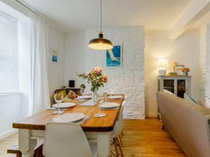 uma sala de jantar com uma mesa de madeira com flores e cadeiras em 3 Bed in Brixham 64703 em Brixham