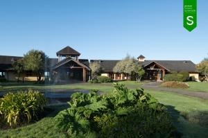 a house with a pond in front of it at Hotel y Cabañas Punta Larga - Caja Los Andes in Frutillar