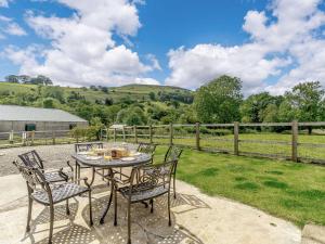 a patio with a table and chairs and a fence at 3 Bed in Helmsley 72267 in Chop Gate